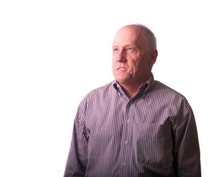 An older bald man in striped shirt looking up with hope or inspiration