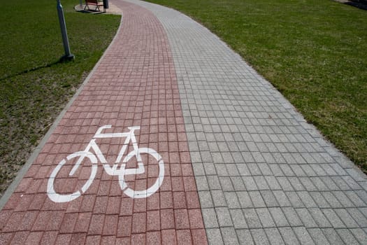 bicycling path with bike sign on a brick pavement