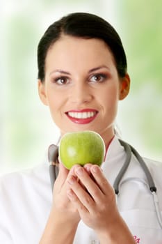 Healthy eating or lifestyle concept. Smiling woman doctor with a green apple.