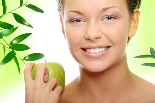 Caucasian beauty with green apple, against abstract green background