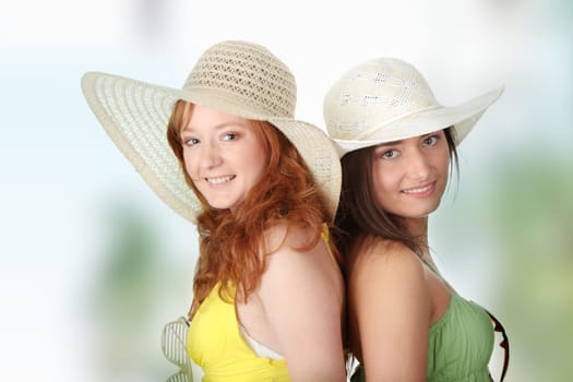 Two girlfriends in summer dress and hat over white background