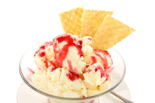 Vanilla ice cream with strawberry topping and golden wafers.