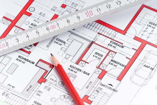 Red pencil with ruler on a house plan