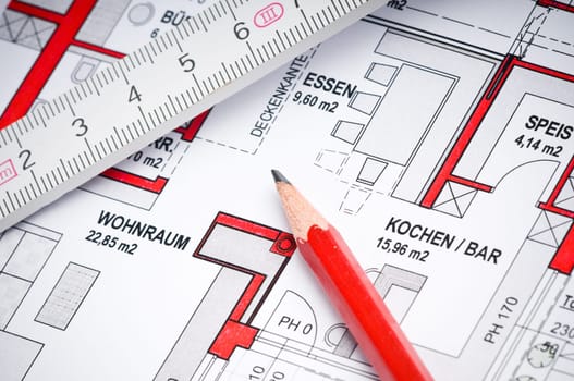 Red pencil with ruler on a house plan