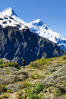 Woman hiker walking the trails looking towards the mountain tops in New Zealand
