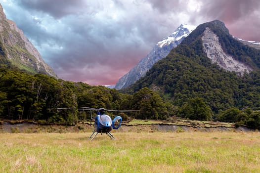 Helicopter landing in a meadow in the Wikin river valley in New Zealand