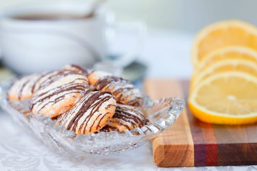 Closeup of a dish of lemon cookies and cut lemon