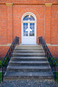 Image of an arched doorway with wreaths on a brick building