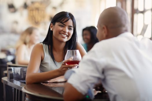 young adult hispanic couple dining out in restaurant and toasting with cocktails. Horizontal shape, front view, focus on background