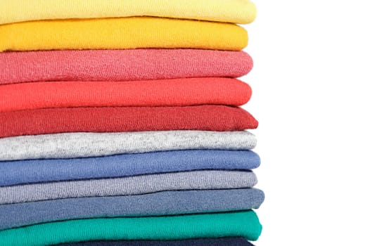 Stack of colored tee shirts on a shelf
