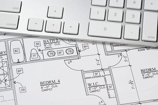 Modern arcbhitect&#039 s offic with blueprint and computer keyboard