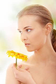Portrait of the attractive girl without a make-up, with flower in hand