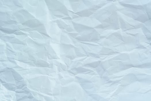 Wrinkled white paper sheet with creases and folds, creating a textured background suitable for design, mockups, or artistic projects.