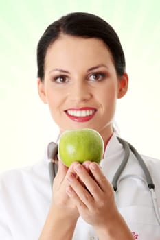 Healthy eating or lifestyle concept. Smiling woman doctor with a green apple.