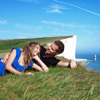 Happy couple smiling on the edge of a white cliff