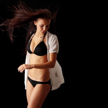 Young beautiful slim woman posing in bikini - with wind - isolated on black
