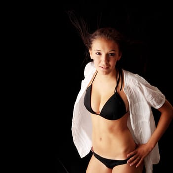 Young beautiful slim woman posing in bikini - with wind - isolated on black