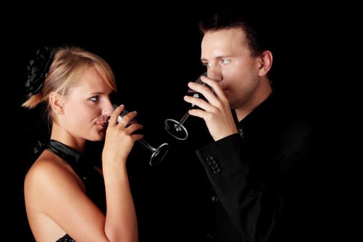 Men, women and red wine. Black background