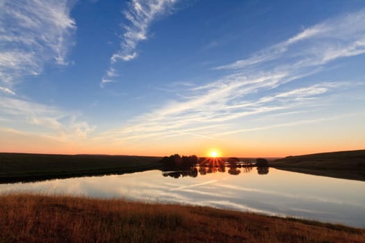 reflection of the sun at sunrise on a lake