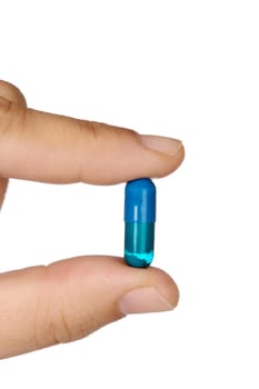 hand with a pill over a white background