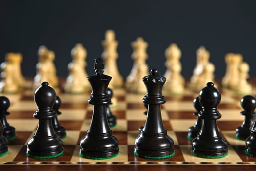Close up of chess pieces on wooden chessboard