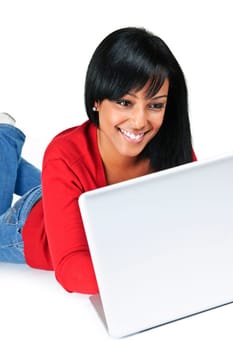 Smiling black woman typing on computer laying on floor