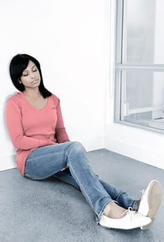 Tired black woman sitting against wall with eyes closed