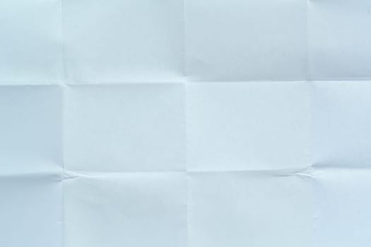 White paper sheet with visible folds and creases, creating a symmetrical textured background suitable for design, mockups, or artistic projects.