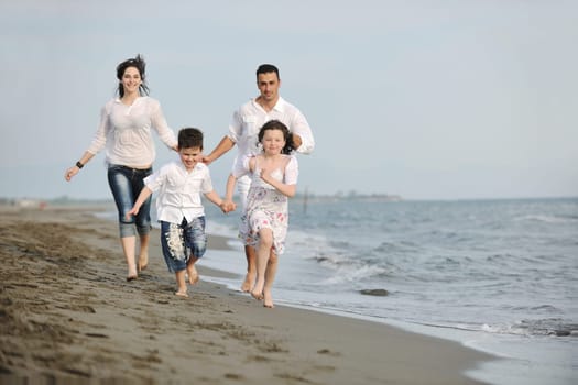 happy young family have fun and live healthy lifestyle on beach