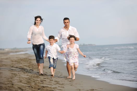 happy young family have fun and live healthy lifestyle on beach