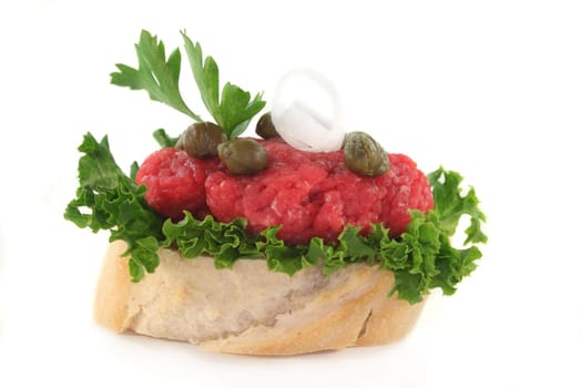 a slice of baguette with tartare and capers