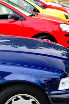 Row of cars in parking lot on a bright day