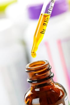 Closeup of liquid medicine in glass dropper and bottle