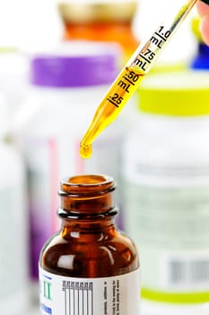 Closeup of liquid medicine in glass dropper and bottle