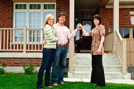 Happy couple getting keys to new house from real estate agent