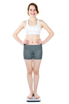 Happy young woman standing on bathroom scale isolated on white