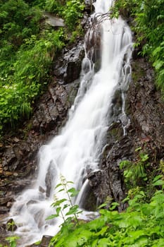 a beautiful waterfall on a mountain slope