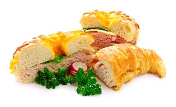 Assorted bagel and croissant sandwiches with meat and vegetables