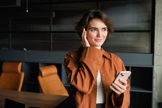 happy employee business woman wearing casual shirt talk speak on mobile cell phone conduct pleasant conversation in office. Achievement career concept.