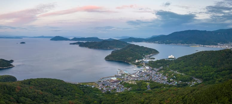 Sunrise color in sky over coastal islands and small village on Shodoshima. High quality photo