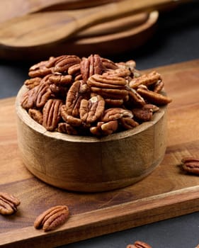 Shelled pecans in a round wooden plate