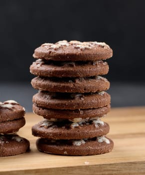 Stack of round chocolate cookies on a black background