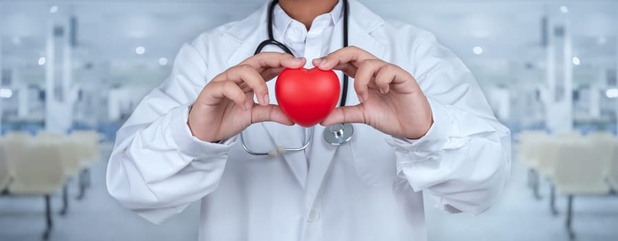 Doctor showing a red heart at hospital represents medical health care and doctor staff service concept.