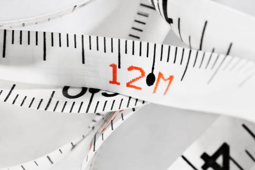 Detail of white measuring  tape with number 12 on white background , carpentry tool ,