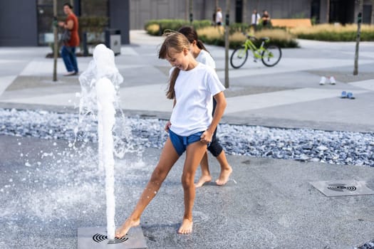 Happy kid playing in a fountain with water. High quality photo