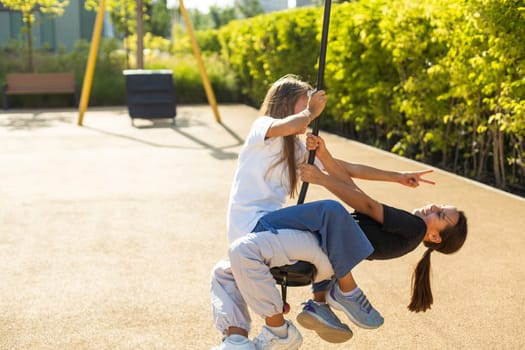 girls teenager swinging on a swing with bare feet on the green lawn of the backyard of his house. High quality photo