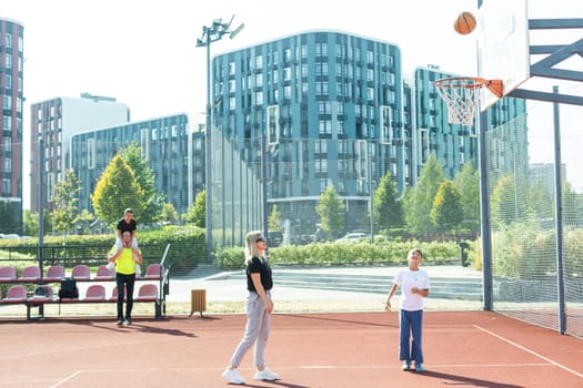 the family plays basketball on the court. High quality photo