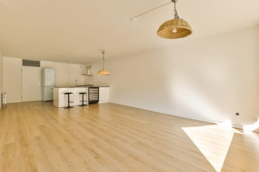 an empty living room with wood flooring and white walls in the room is very light, bright and clean