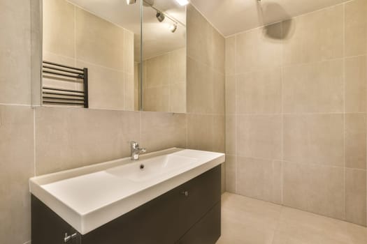 a bathroom with a sink, mirror and towel rack on the wall next to the bathtub is white tile