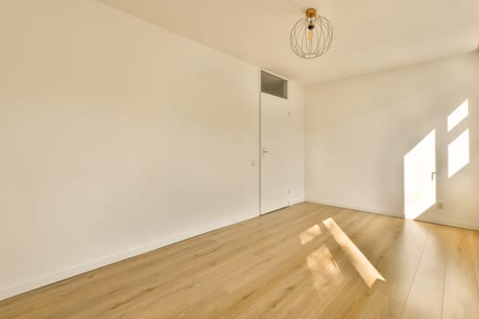 an empty room with wood flooring and white walls in the room is bright sunlight shining through the window on the wall